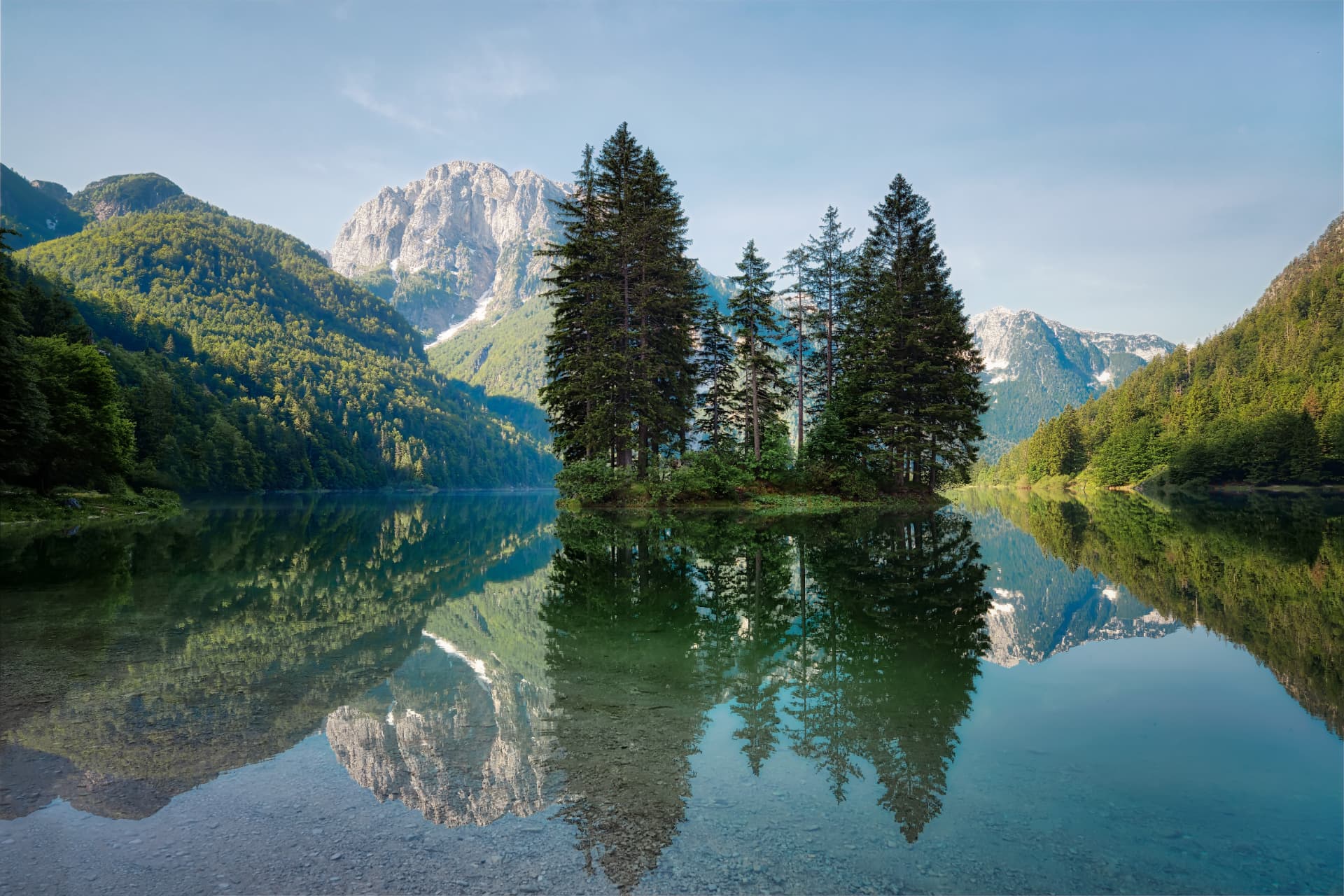 Alpine lake surrounded by forested mountains, symbol of Caldana Europe Travel's local presence in northern Italy