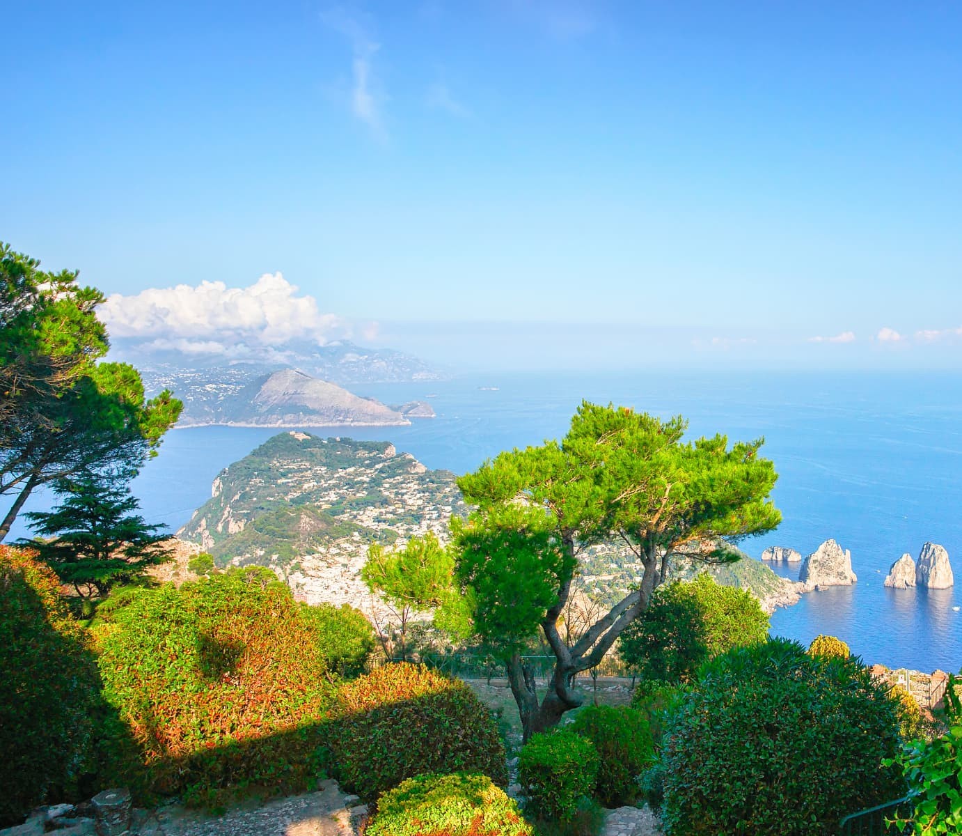 A Roman statue overlooking the sea and the Faraglioni rocks of Capri