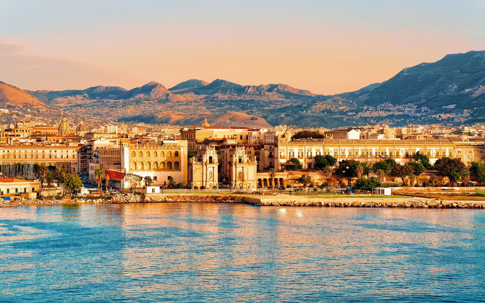 The seafront of Palermo at sunset with Porta Felice and the mountains behind